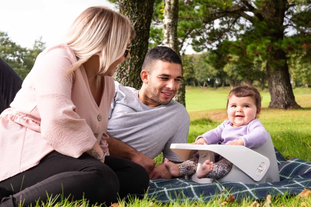 Happy family enjoying BabyDam Products, featuring the SpongePod feeding seat at a picnic