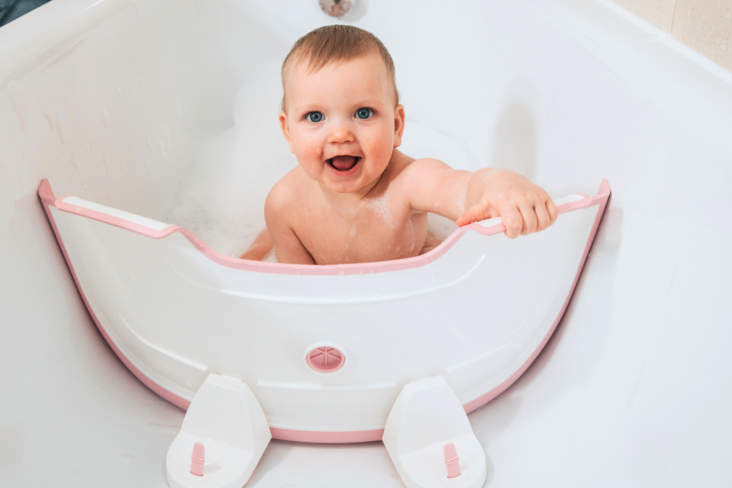 Award winning BabyDam Bathwater Barrier baby in bath pink